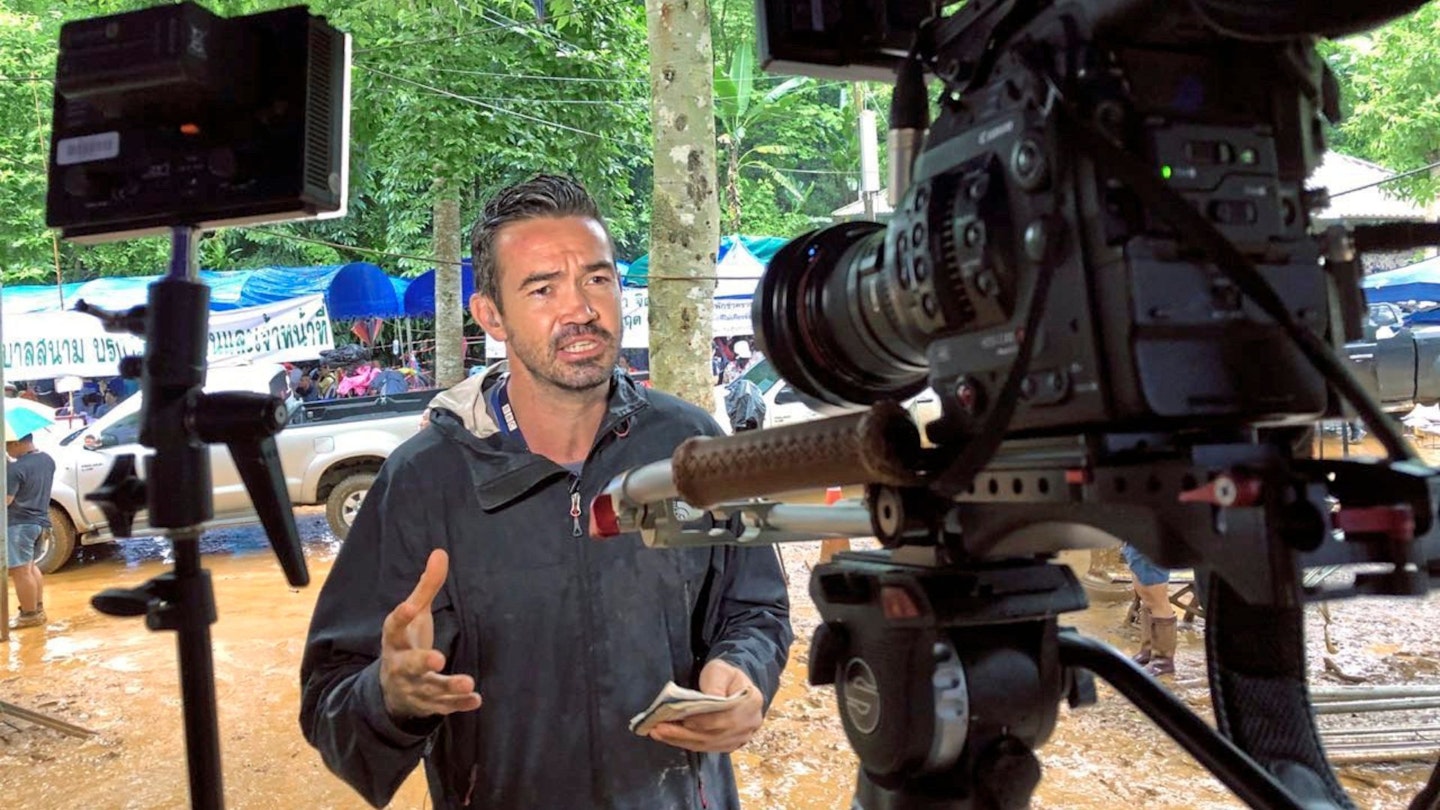 Howard Johnson talking to a camera in front of flooded ground