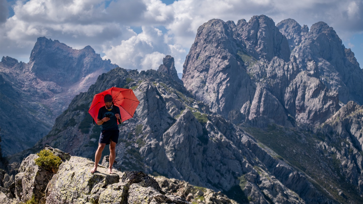 Gear expert Ben Weeks using the Decathlon profilter small umbrella in the mountains