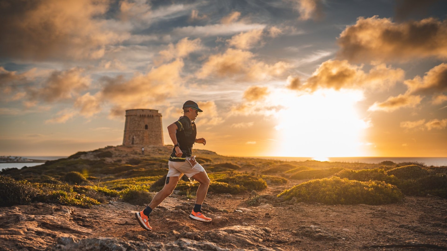 Trail running in Menorca along the coast, with a sunset