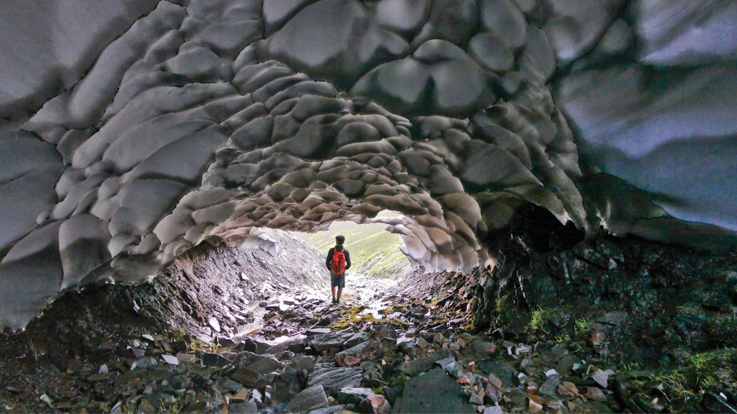 A man in a snow tunnel in the Cairngorms