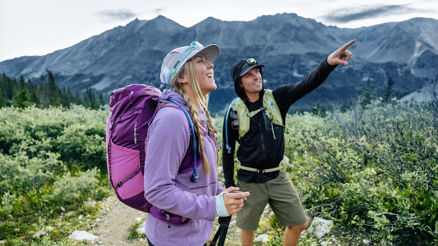 Man pointing at mountain wearing deuter rucksack