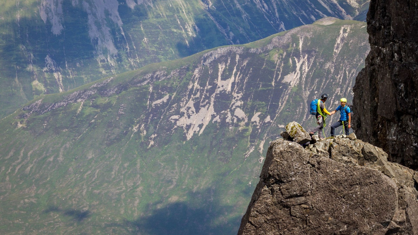 Two climbers at the top of Naismith's route Bhasteir Tooth, Cuillin Ridge Skye