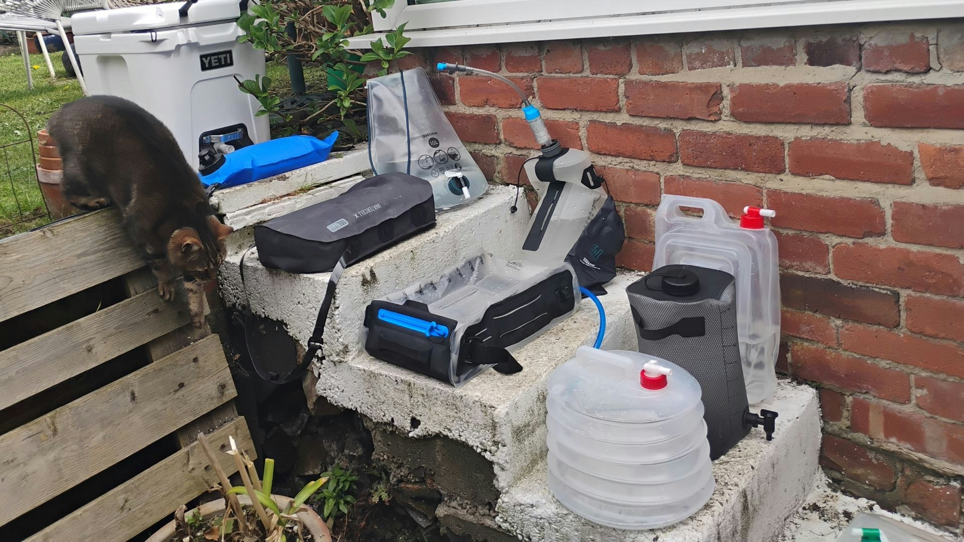 all of the camping water containers on some stairs in a garden