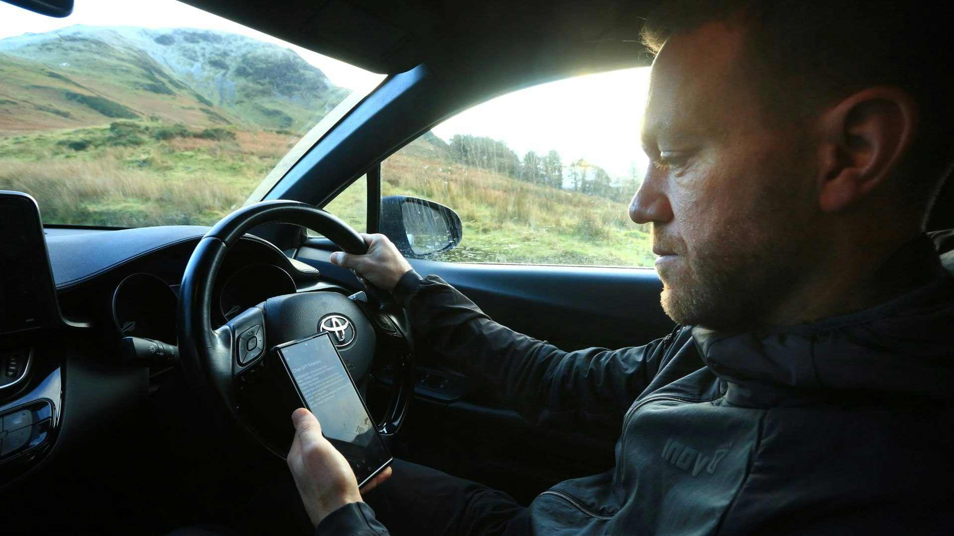 James checks ChatGPT on his phone in the car