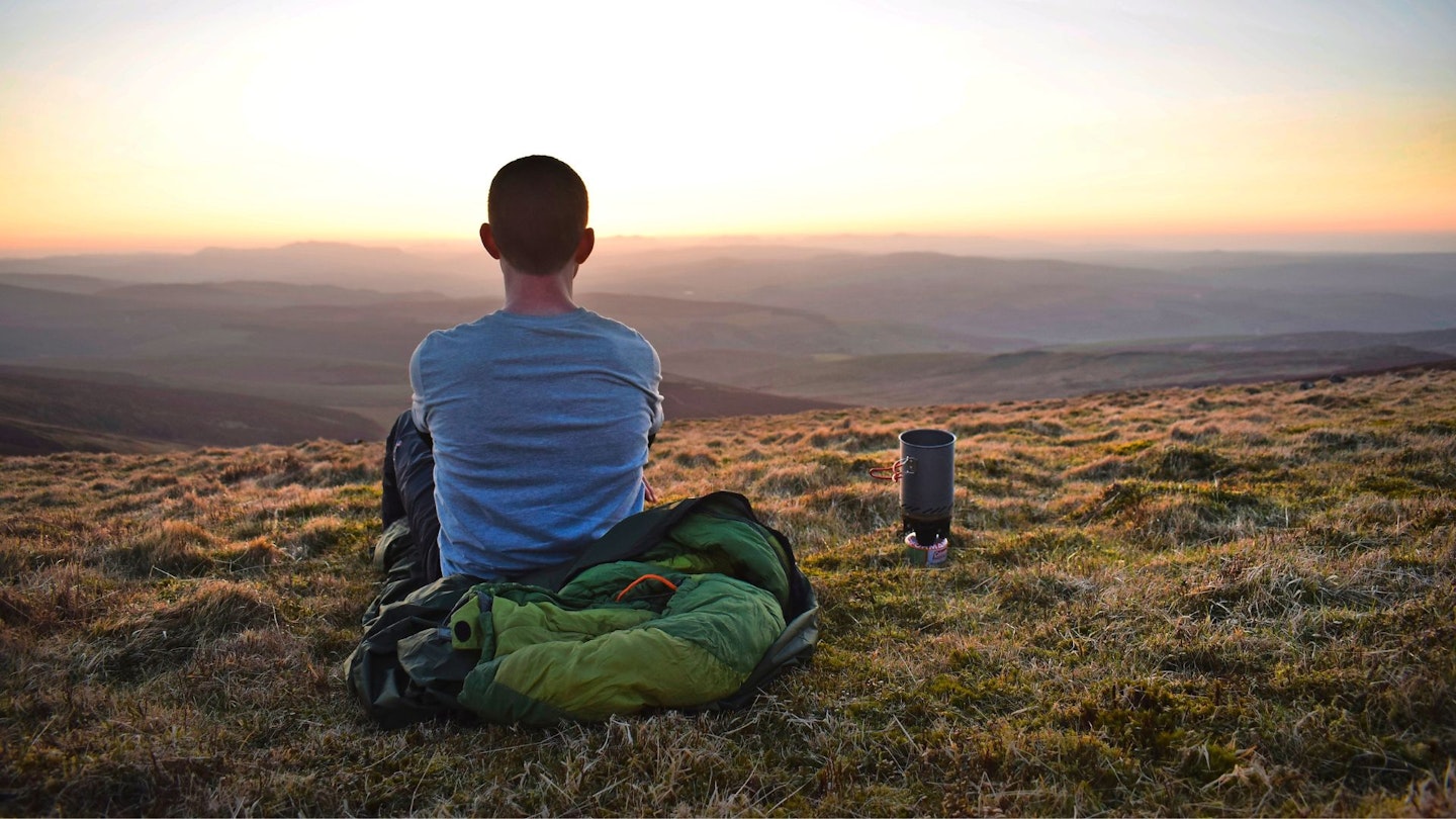 Hiker bivvying on a hilltop