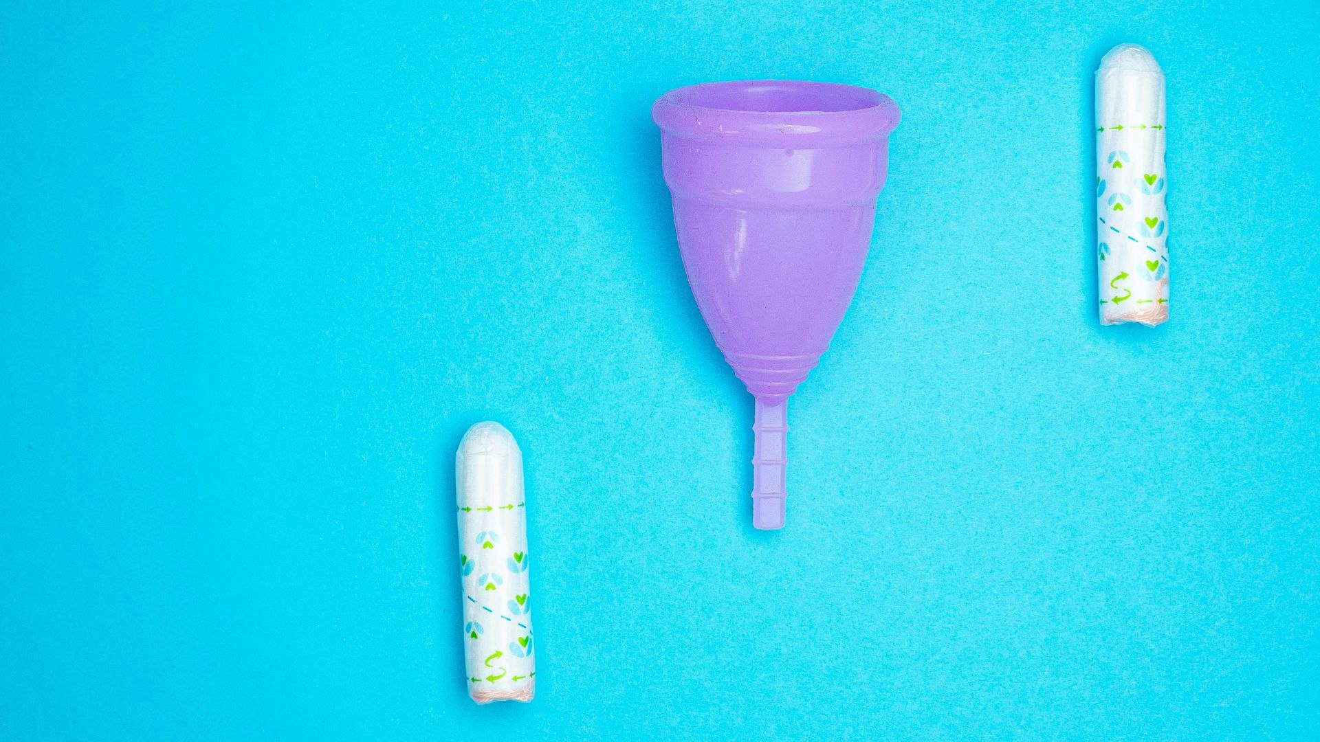 Tampons and a menstrual cup against a bright blue background