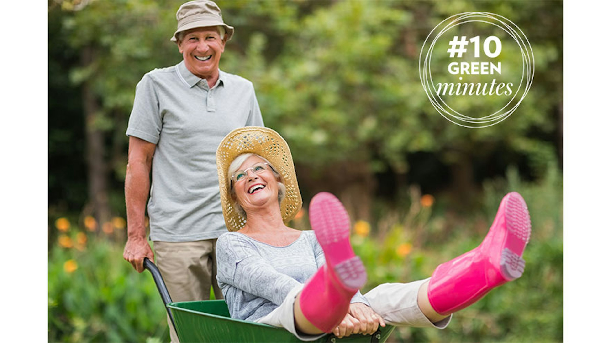 man and woman in wheelbarrow having fun in garden