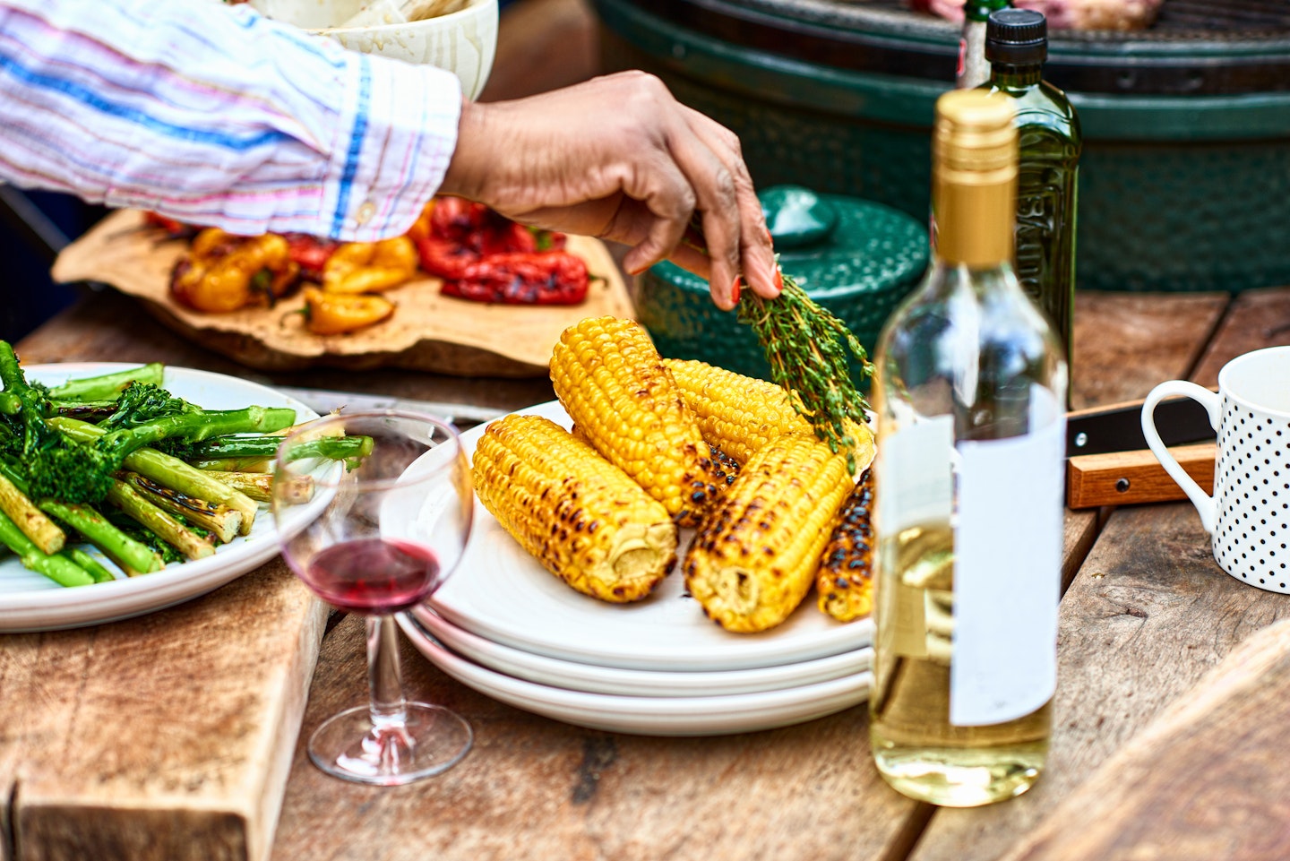 Plate of freshly barbecued corn on the cob and herbs