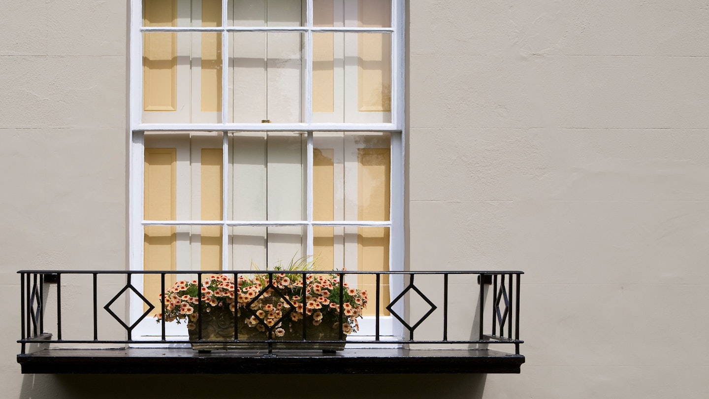 An elegant and tasteful window in yellow, The harmony between the yellow shutters and the chosen yellow flowers in the traditional window box delights the passing pedestrians.