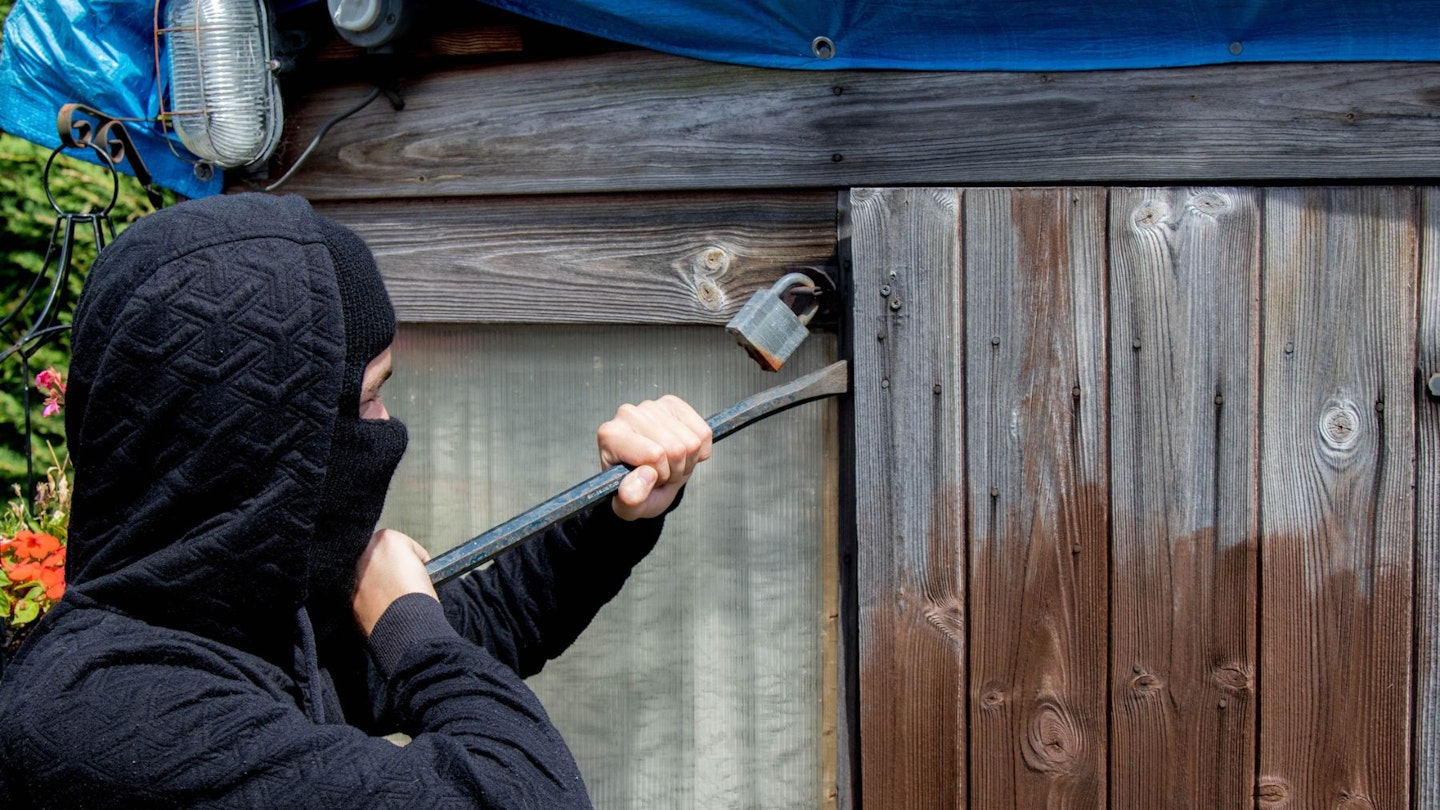 Burglar breaking into shed