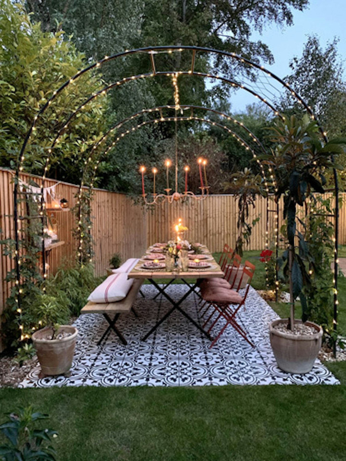 garden dining table lit up with overhead fairylights