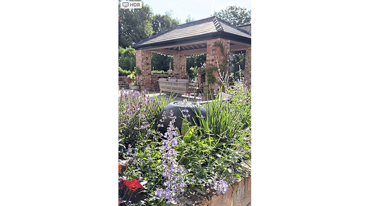 globe water feature in bed of flowers