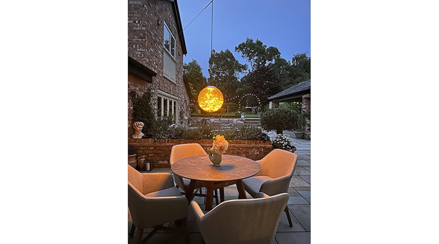 round outdoor table with globe light above
