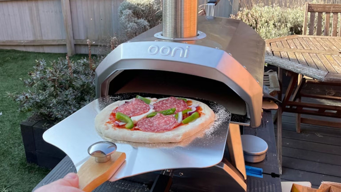 Testing the Ooni Karu 12, sliding a homemade pizza into the pizza oven
