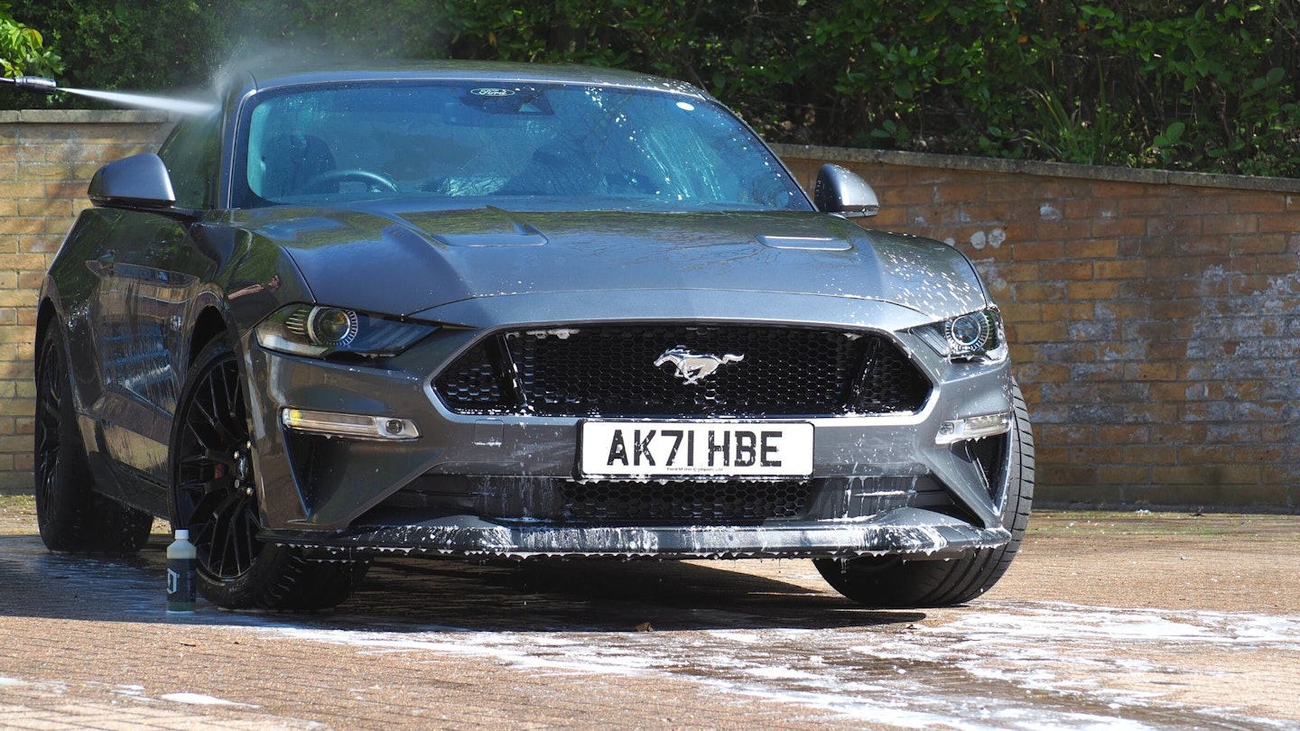 Rinsing a grey Ford Mustang with a pressure washer - car cleaning kits