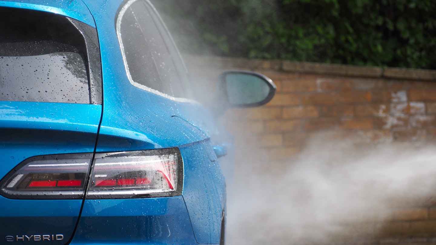 Pressure washer spraying a blue VW Arteon
