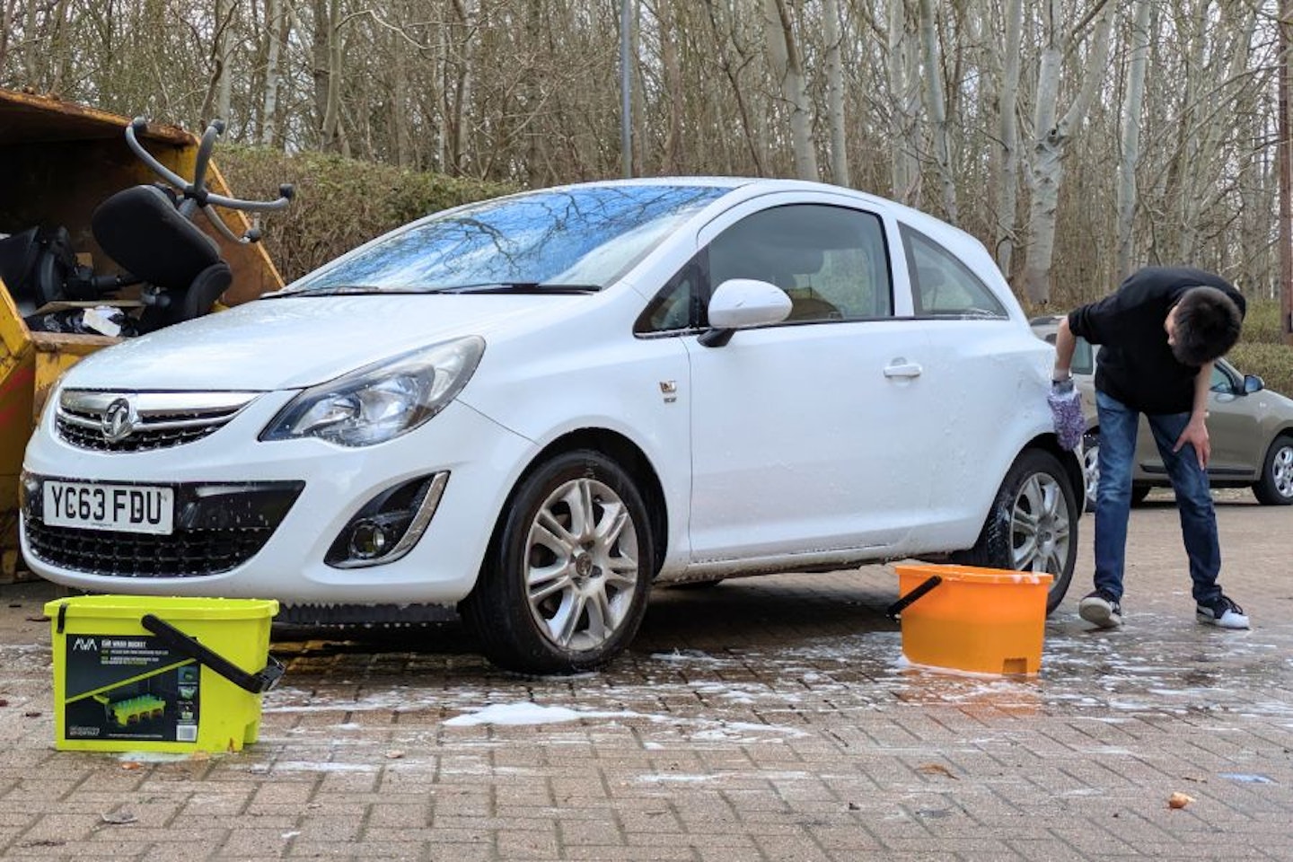 Aaron Hussain cleaning a Vauxhall Corsa