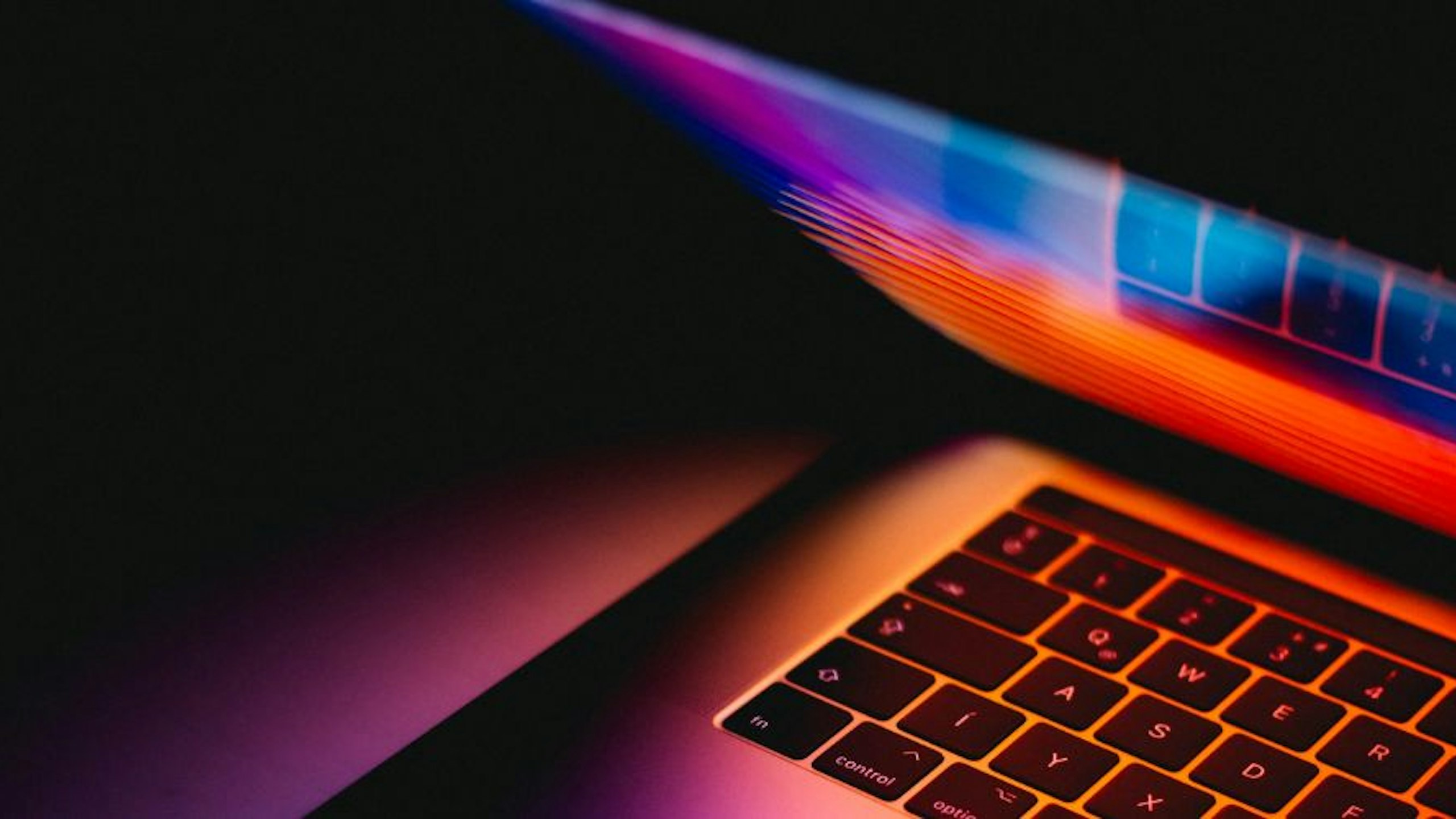 MacBook Pro video editing laptop turned on displaying colours
