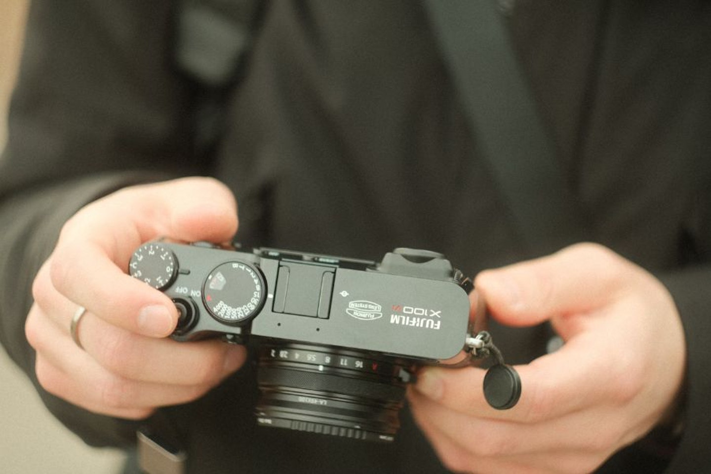 A man holding one of the best point and shoot cameras, the FUJIFILM X100VI, in his hands