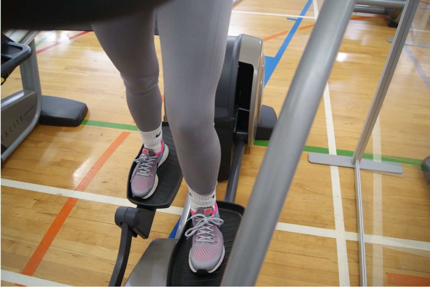A woman wearing a pair of the best women's running tights while on the Cross Trainer in a gym.