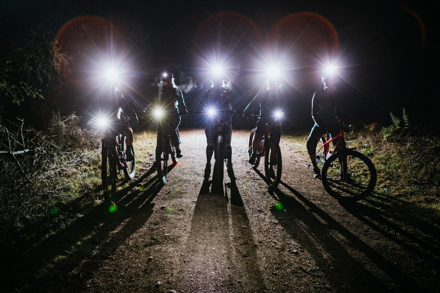 Bike riders with front bike lights on in the dark