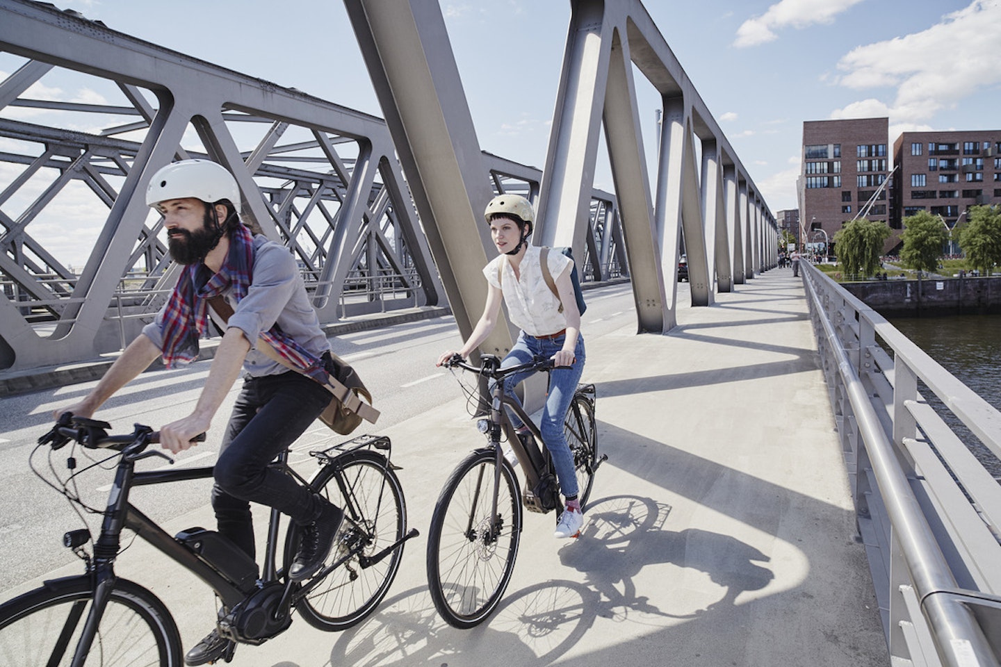 couple riding hybrid electric bikes through a city