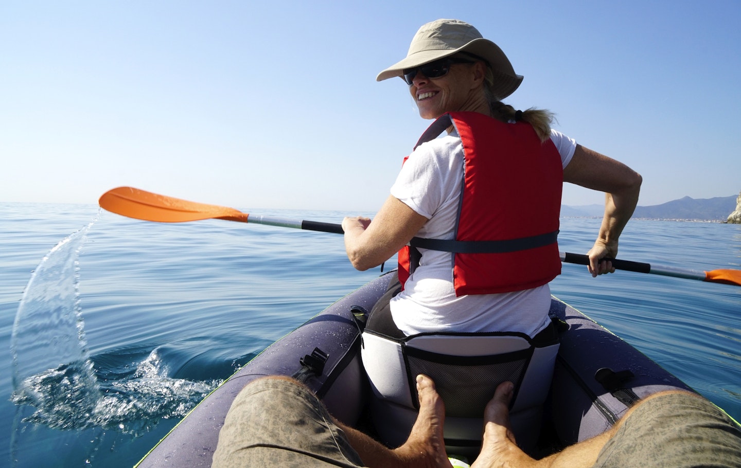 A woman looking back at a passenger while paddling an inflatable kayak - The best inflatable kayaks