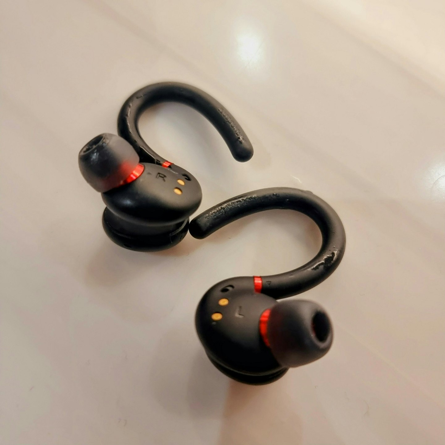 Soundcore Anker Sport earbuds on a hard surface with moisture on the surface