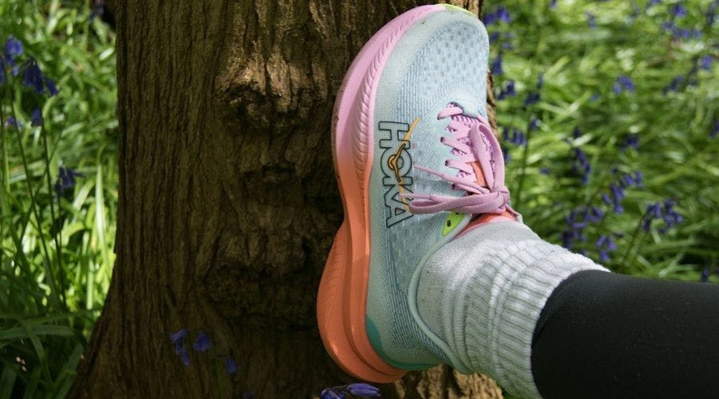 Hoka Mach 6 trainers being worn. Placed against tree. One of the best beginner running shoe options.