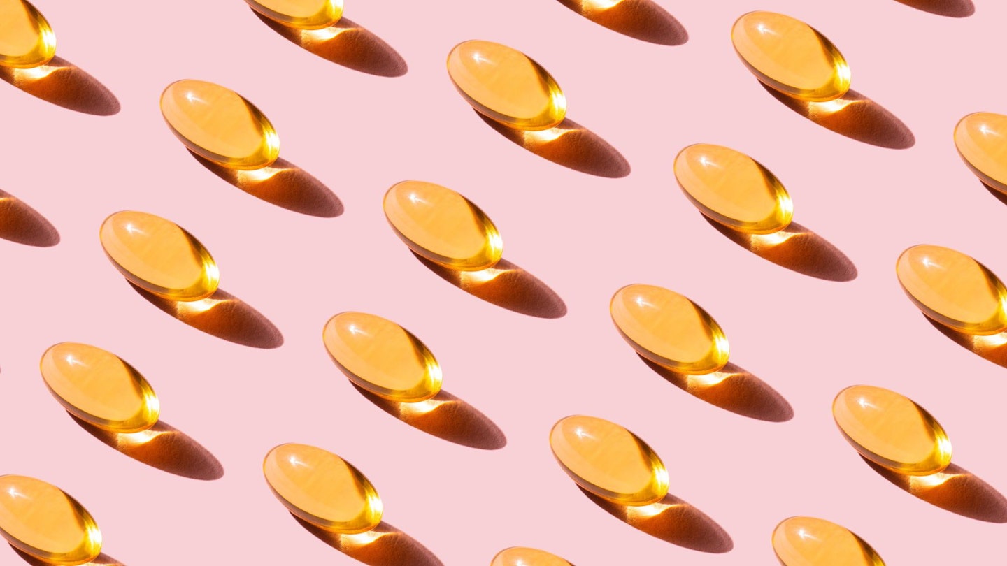 Pattern of yellow Fish Oil vitamins with Omega-3 repetition on Pink Background for winter