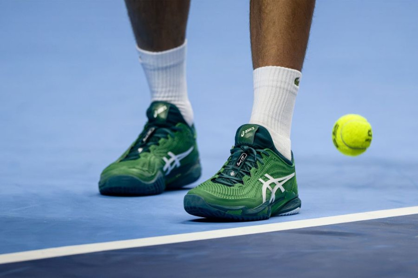 A pair of Asics trainers on a tennis court