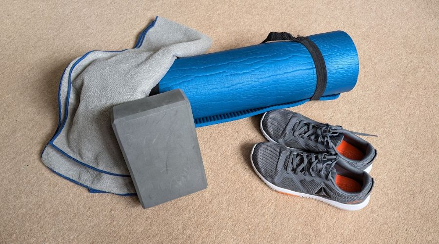 Rolled up yoga mat with towel, yoga block and trainers