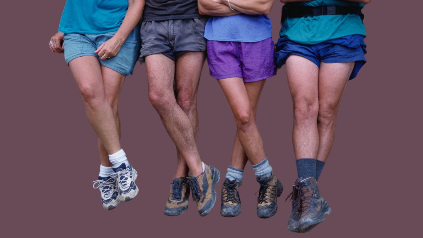 Four individuals wearing the best walking shorts on a brown background