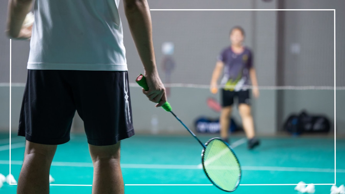 A man with his back towards the camera playing badminton, wearing the best badminton outfit