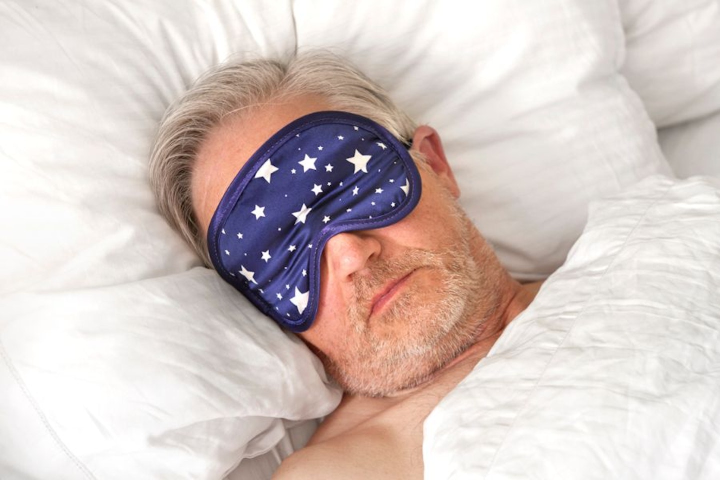 Man wearing eye mask in bed - close up