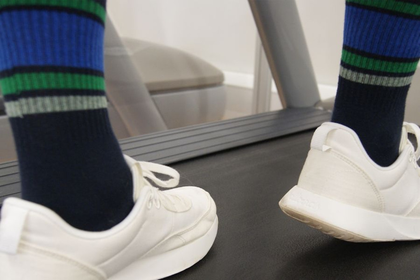 Man walking on a treadmill wearing socks and trainers