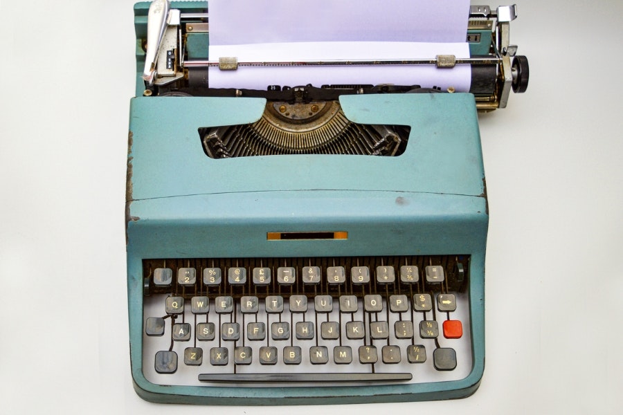 A blue typewriter on a white background