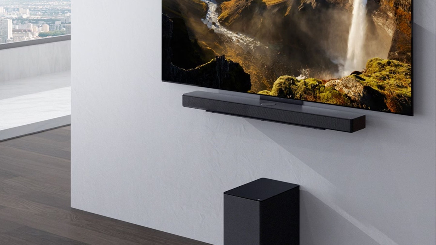 A wall mounted soundbar underneath a television