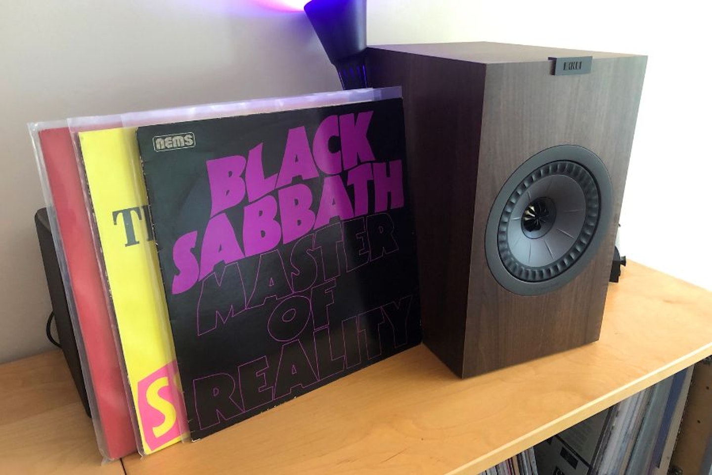 some vinyl records and a kef bookshelf speaker