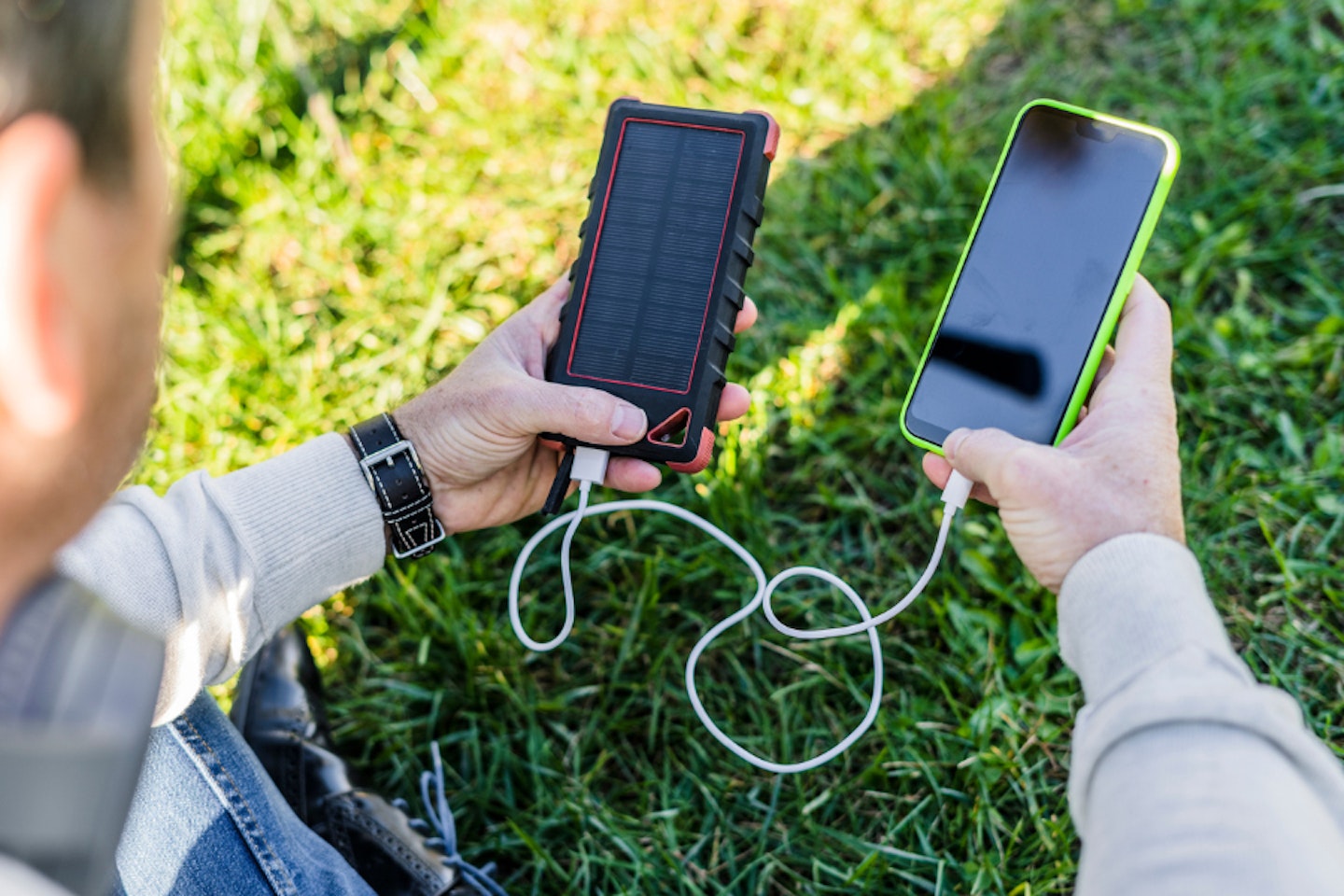 Person using the best solar power bank to charge phone