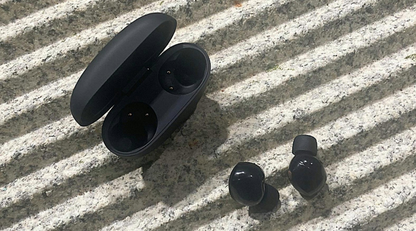 Sony WF-1000XM5 headphones on jagged surface. Essential holiday tech.