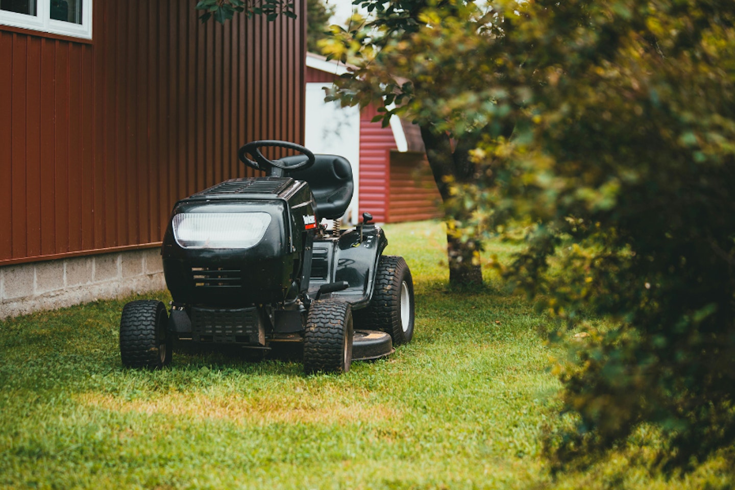 A black ride-on petrol lawn mower