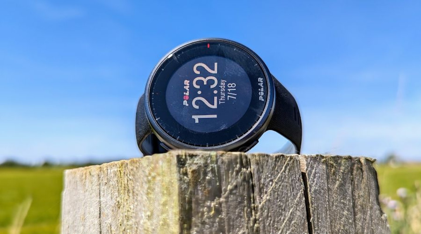 Polar Vantage V2 watch on a fence post, bright blue sky in the background