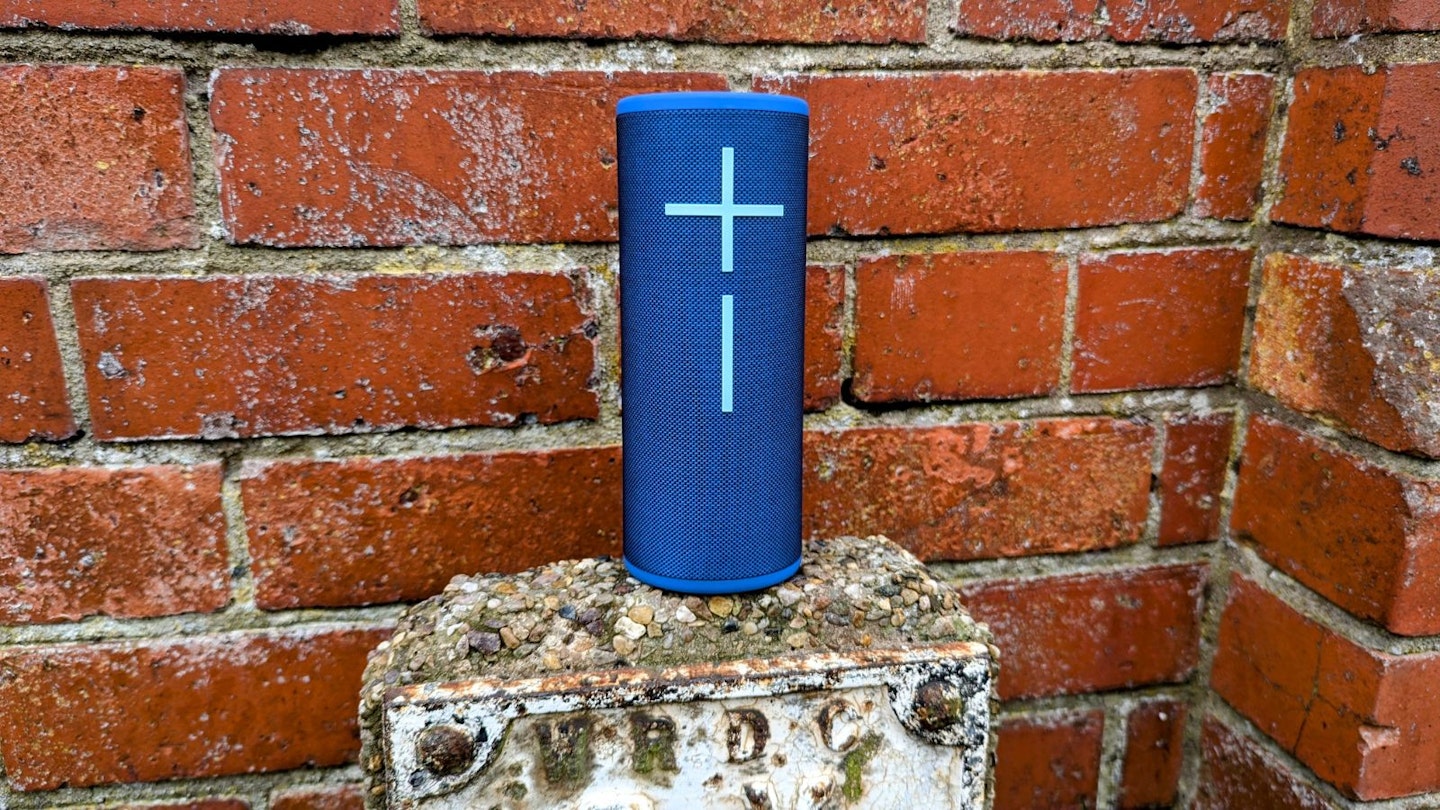 UE Boom 4 speaker against a red brick wall