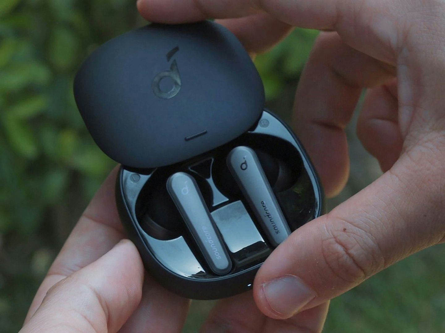 A man holding a pair of Bluetooth earpods