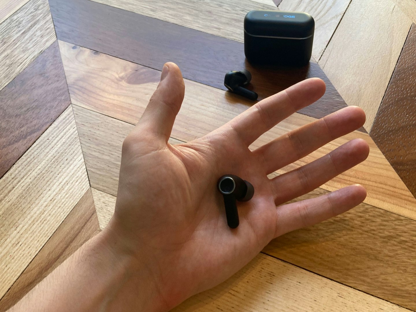 Cambridge Audio Melomania A100 earbuds in hand and case