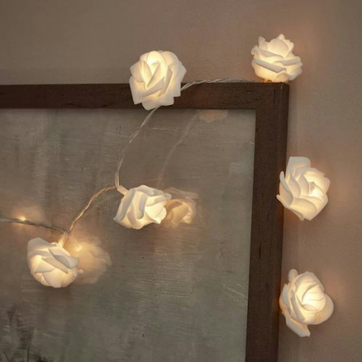 lifestyle image of 20 Warm White LED Rose Flower Battery Fairy Lights detail draped around a picture frame