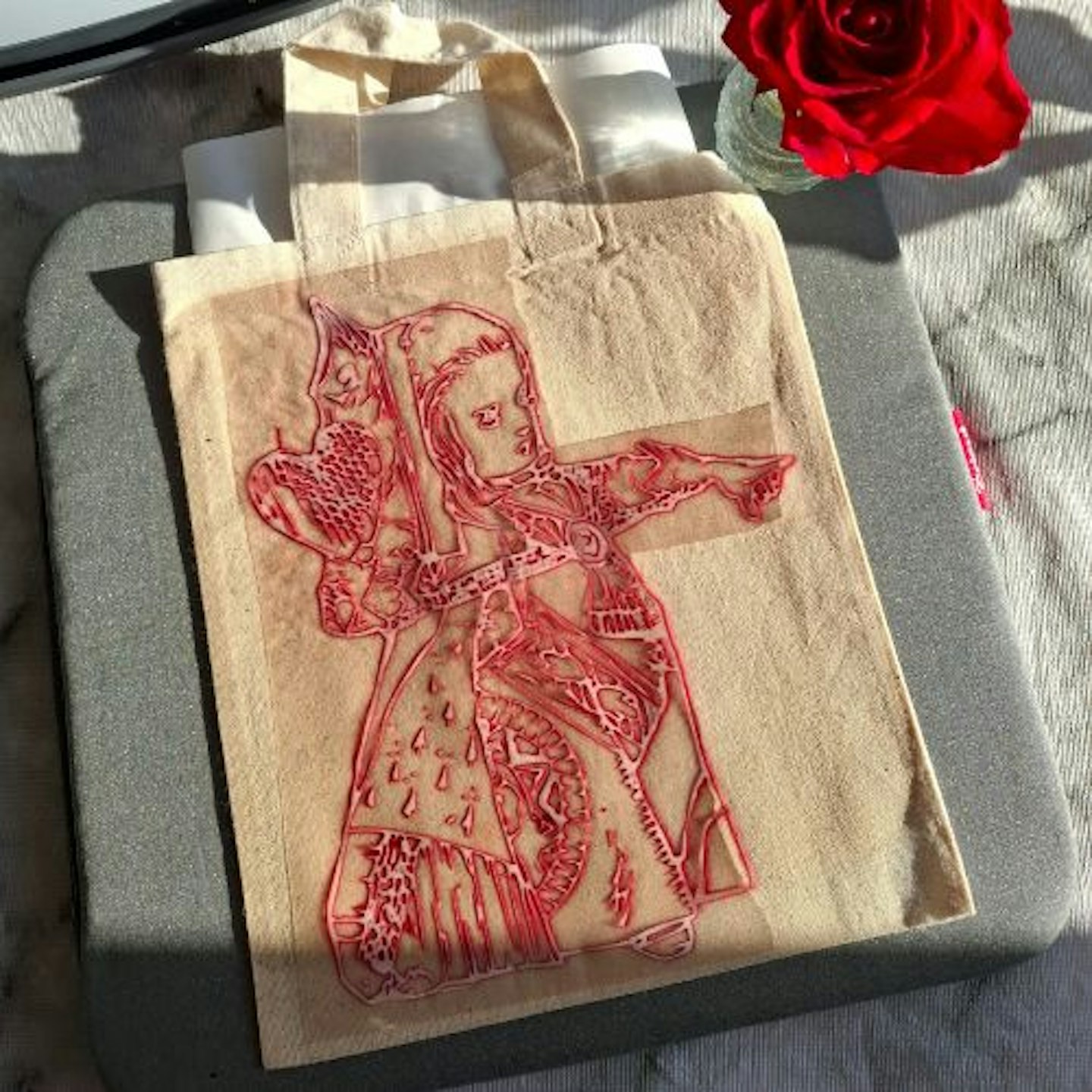 Natalie's Alice In Wonderland illustration transferring to fabric using Infusible Ink. Red rose and heat mat in background