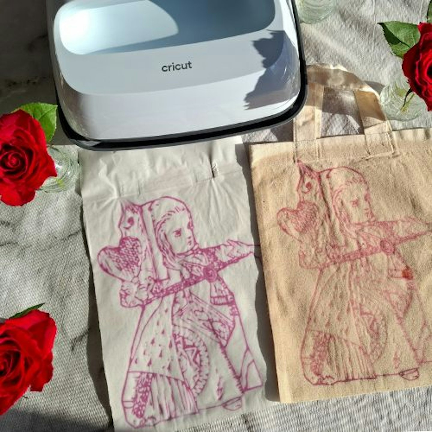 Close up detail of Alice in Wonderland design and Cricut EasyPress 3 surrounded by red roses