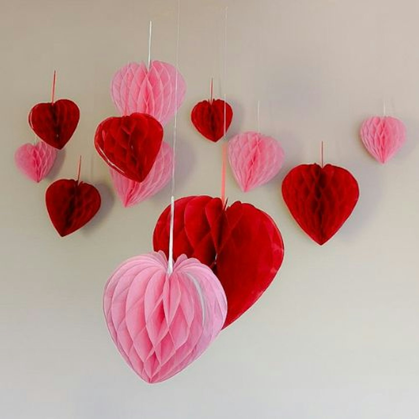 Premium Reusable Valentines Decorations hanging from different heights against an off-white background
